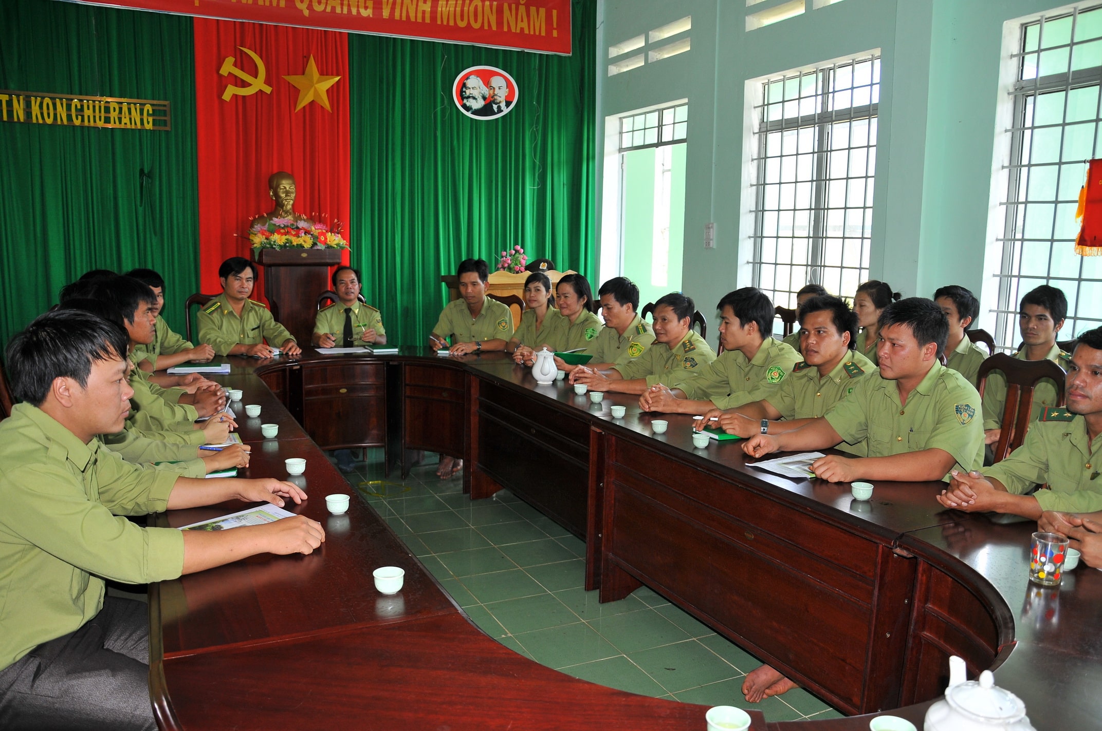 Lực lượng bảo vệ rừng mặc đồng phục dự họp quanh bàn hội trường